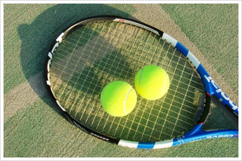 ガットの貼られたテニスラケットとボール